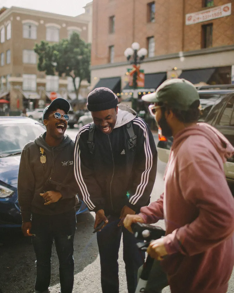 Three friends laughing on a city street